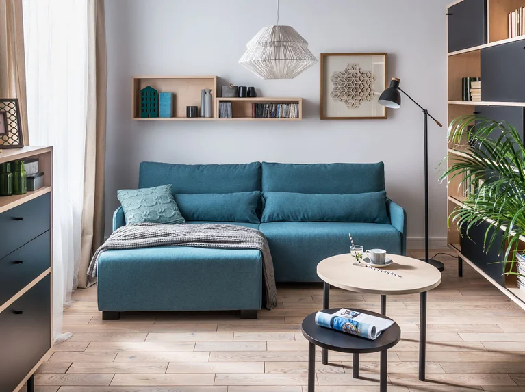 Kompaktowy turkusowy narożnik w minimalistycznym salonie.